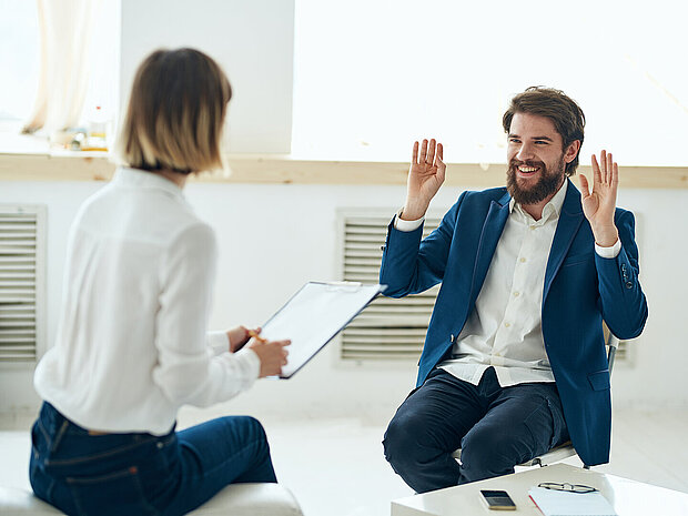 a man explains something to a woman to a psychologist indoors near a window HSKL