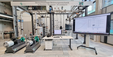 Pumpenversuchsstand, Schreibtisch, Großbildschirm mit Diagrammen und Text